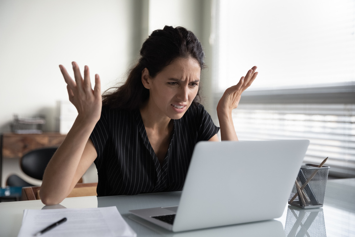 Image of woman looking at laptop, exasperated