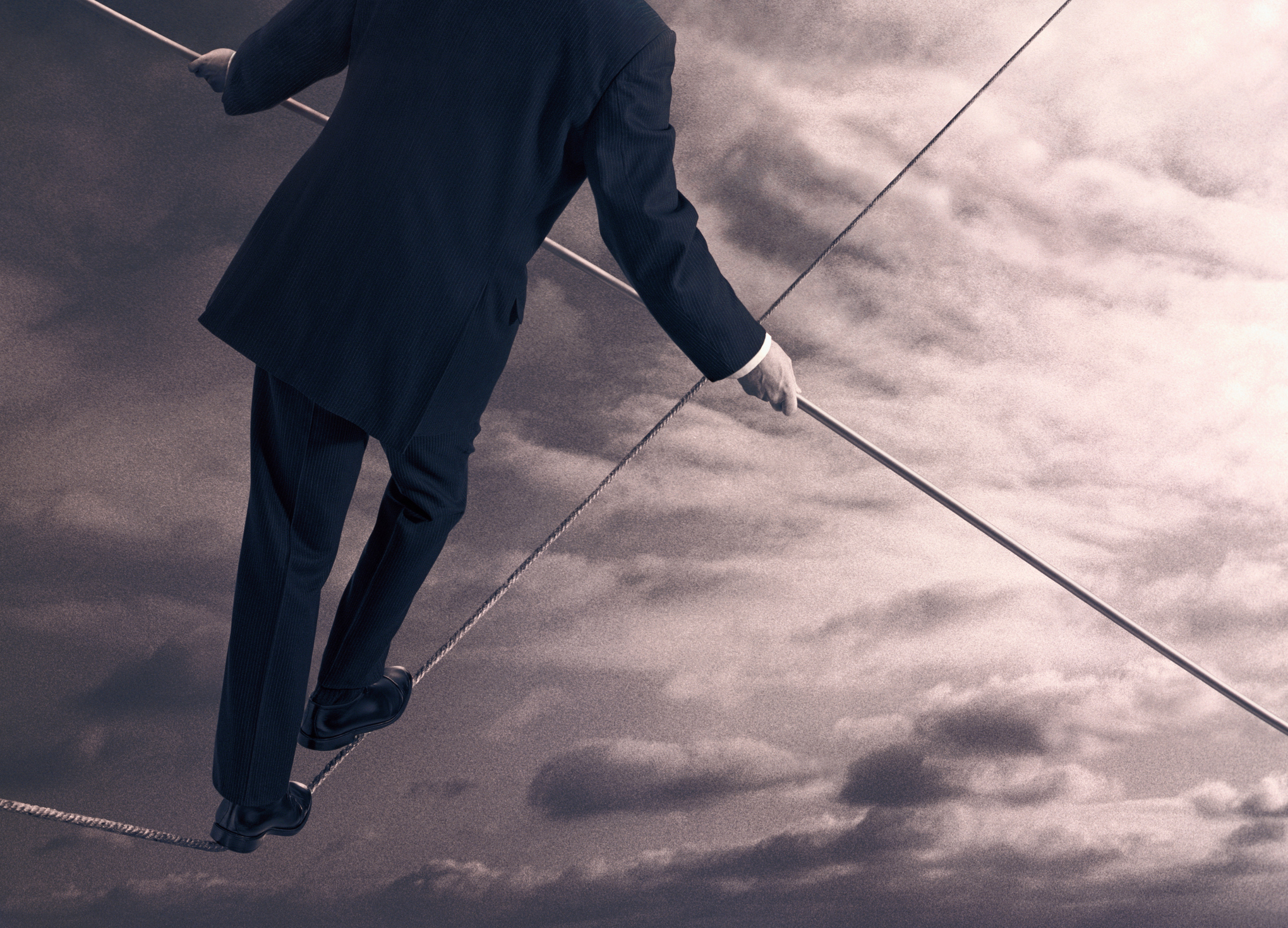 Image of businessman walking on tightrope